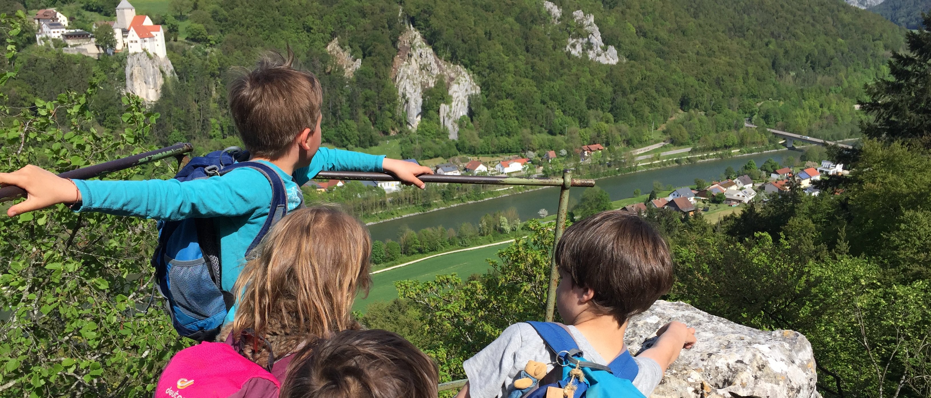 Auf diesem Bild sieht man Kinder die Aussicht auf Burg Prunn bewundern
