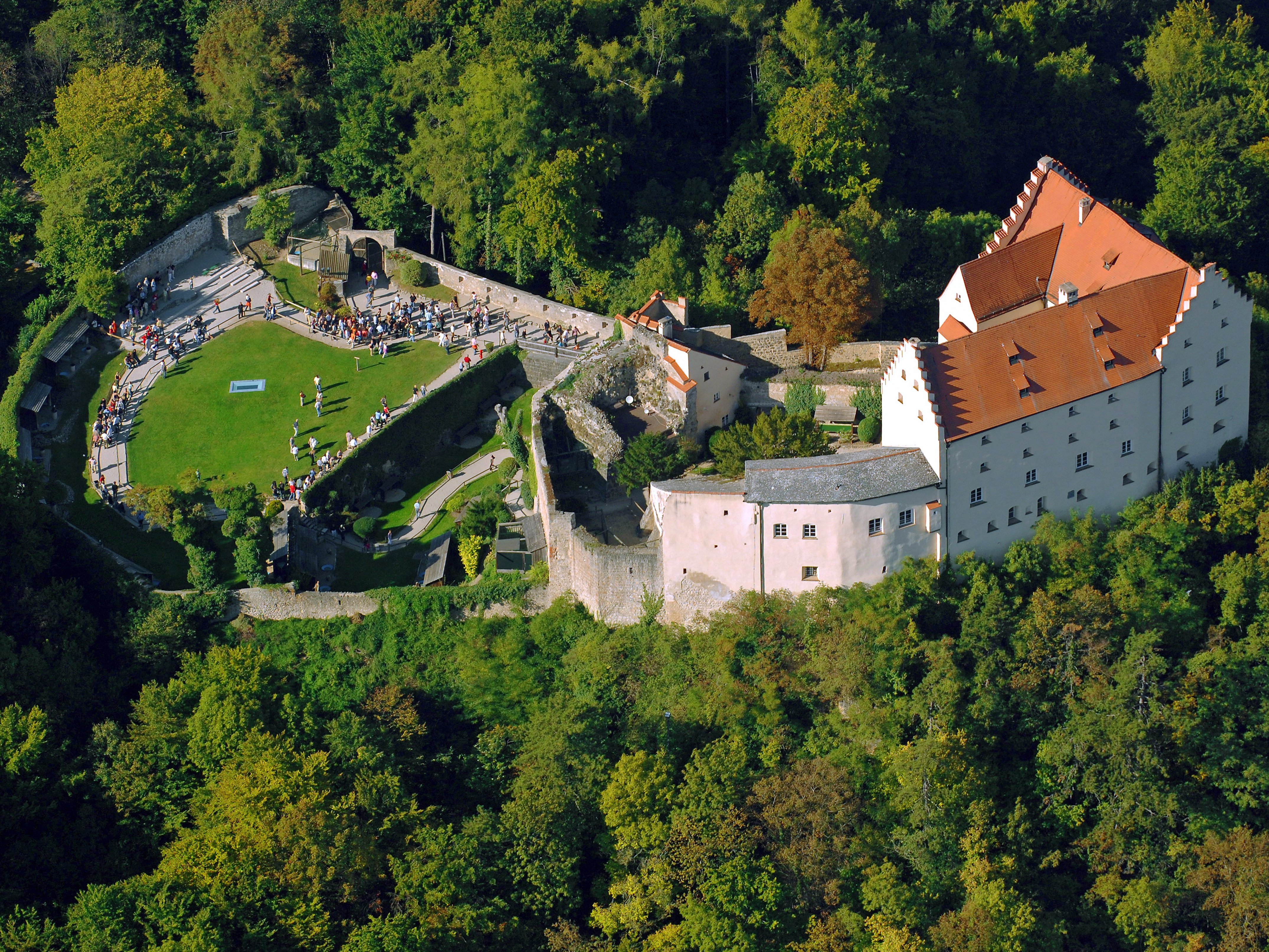 Es ist eine Luftbildaufnahme vom Schloss Rosenburg zu sehen während einer Falkenschau